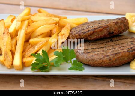 Leckere Burger gefüllt, begleitet von Country Style Kartoffeln und Sauce Stockfoto