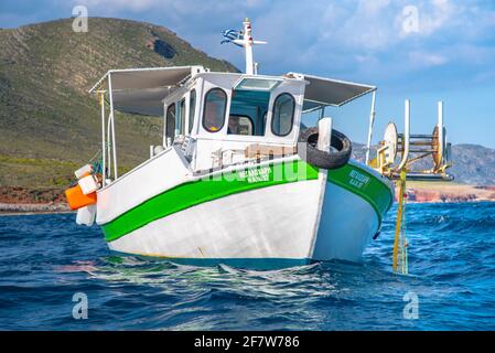 Fisherman fischt frische Fische mit gelben Fischernetzen auf einem Fischerboot, Kreta, Griechenland Stockfoto