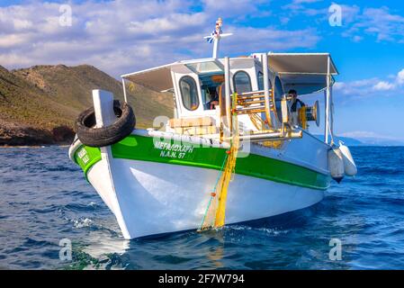 Fisherman fischt frische Fische mit gelben Fischernetzen auf einem Fischerboot, Kreta, Griechenland Stockfoto
