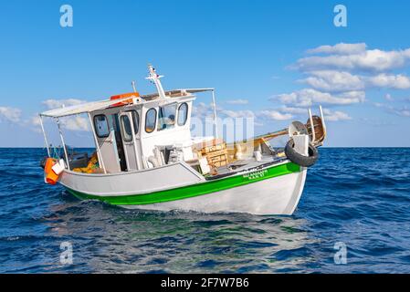 Fisherman fischt frische Fische mit gelben Fischernetzen auf einem Fischerboot, Kreta, Griechenland Stockfoto