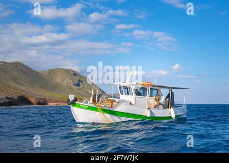 Fisherman fischt frische Fische mit gelben Fischernetzen auf einem Fischerboot, Kreta, Griechenland Stockfoto