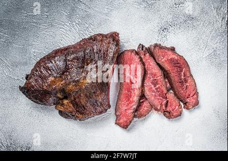 Gebratener Aufhänger oder Onglet-Rindersteak in Scheiben auf einem Tisch. Weißer Hintergrund. Draufsicht Stockfoto
