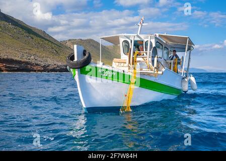 Fisherman fischt frische Fische mit gelben Fischernetzen auf einem Fischerboot, Kreta, Griechenland Stockfoto