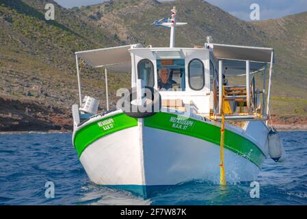 Fisherman fischt frische Fische mit gelben Fischernetzen auf einem Fischerboot, Kreta, Griechenland Stockfoto