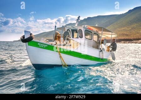 Fisherman fischt frische Fische mit gelben Fischernetzen auf einem Fischerboot, Kreta, Griechenland Stockfoto