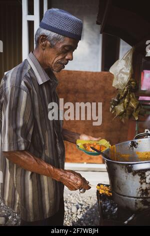 MINANG, INDONESIEN - 12. Februar 2021: Mann bereitet Sate padang vor. Hühnersticks mit der Speciasauce Stockfoto