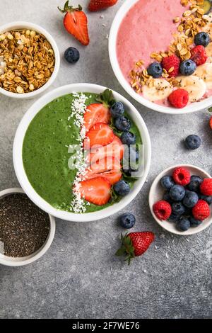 Matcha Grüner Tee Frühstück Superfoods Smoothies Schüssel mit Erdbeeren, Heidelbeeren, Kokosflocken obendrauf, Draufsicht, flach legen Stockfoto