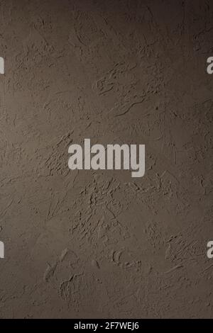 Hintergrundtextur der Wand als abstrakte Oberfläche. Künstlerischer dunkler Kitt Hintergrund Stockfoto