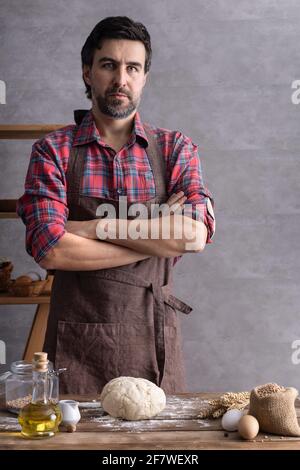 Bäckermann macht Teig und Backzutaten für selbstgebackenes Brot Kochen auf dem Tisch. Bäckerkonzept und männliche Hand Stockfoto