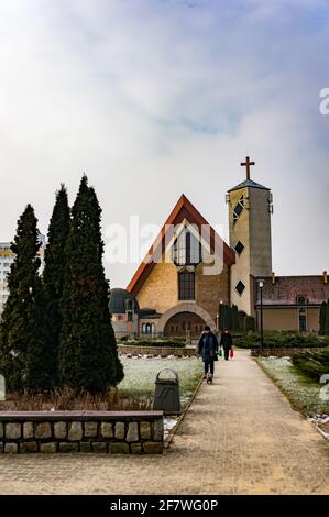 POZNAN, POLEN - 10. Feb 2018: Menschen, die auf einem Fußweg vor einer Kirche im Piastowskie-Gebiet spazieren Stockfoto