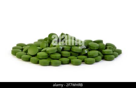 Grüne Spirulina Tabletten isoliert auf weißem Hintergrund. Stockfoto