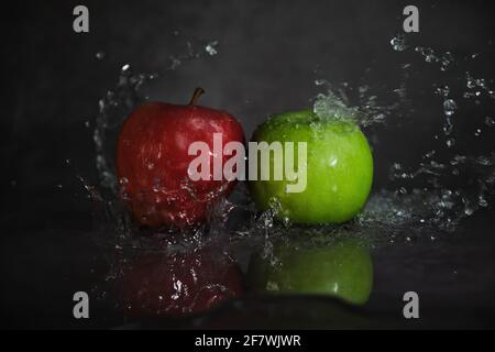 Rote und grüne Äpfel in Wasserspritzern Stockfoto