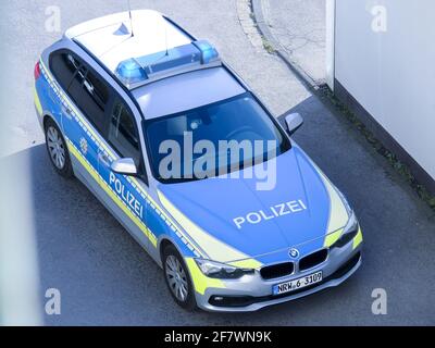 DORTMUND, DEUTSCHLAND - 03. Apr 2021: Deutscher stehender Polizeiwagen von oben in den Farben Blau, Grau und Gelb fotografiert, vor einem Haus geparkt Stockfoto