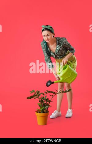 Junge Gärtnerin auf farbigem Hintergrund Stockfoto