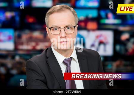 Ein Anchorman, der im Fernsehstudio aktuelle Nachrichten berichtet. Hintergrund mehrerer Bildschirme des Kontrollraums. Journalismus-Konzept Stockfoto