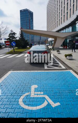 POZNAN, POLEN – 30. März 2018: Blauer Parkplatz für Behinderte und geparktes Auto vor dem Mercure Hotel in der Straße Roosevelta Stockfoto