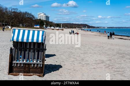 Timmendorfer Strand, Deutschland. April 2021. Am Timmendorfer Strand wandern die Menschen bei strahlendem Sonnenschein am Ufer der Ostsee entlang, vorbei an den ersten in diesem Jahr aufgestellten Strandliegen. Quelle: Axel Heimken/dpa/Alamy Live News Stockfoto