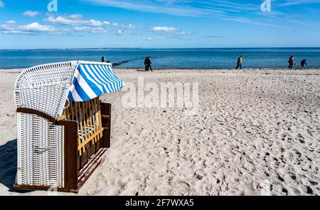 Timmendorfer Strand, Deutschland. April 2021. Hinter den ersten Strandliegen am Timmendorfer Strand laufen die Menschen in strahlendem Sonnenschein am Ufer der Ostsee entlang. Quelle: Axel Heimken/dpa/Alamy Live News Stockfoto