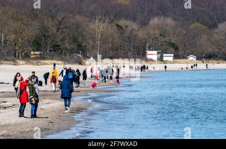 Timmendorfer Strand, Deutschland. April 2021. Am Timmendorfer Strand wandern die Menschen bei strahlendem Sonnenschein am Ufer der Ostsee entlang. Quelle: Axel Heimken/dpa/Alamy Live News Stockfoto