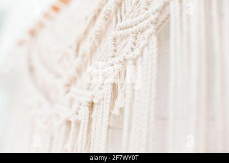 Handgemachtes Makramenmuster ein Fragment einer Wandtafel in Der Boho-Stil aus beigefarbenen Baumwollfäden mit natürlicher Farbe Mit der Technik für zu Hause und Weddin Stockfoto