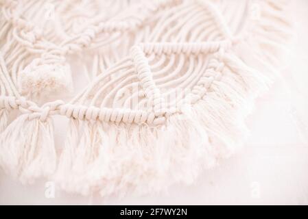 Handgemachtes Makramenmuster ein Fragment einer Wandtafel in Der Boho-Stil aus beigefarbenen Baumwollfäden mit natürlicher Farbe Mit der Technik für zu Hause und Weddin Stockfoto