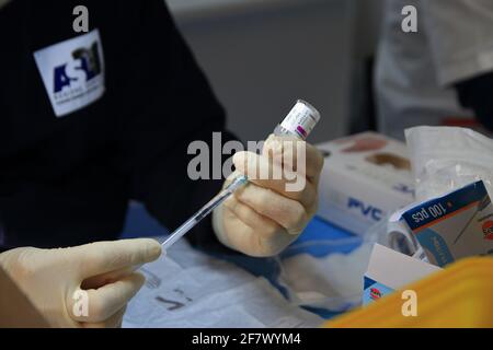 Krankenschwestern in der Apotheke bereiten unter Anleitung eines Arztes Spritzen mit Dosen von pfizer-biontech-Impfstoff oder astrazeneca vor. Stockfoto