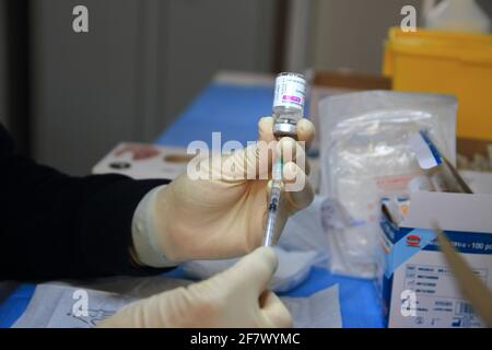 Krankenschwestern in der Apotheke bereiten unter Anleitung eines Arztes Spritzen mit Dosen von pfizer-biontech-Impfstoff oder astrazeneca vor. Stockfoto