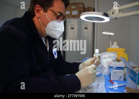 Krankenschwestern in der Apotheke bereiten unter Anleitung eines Arztes Spritzen mit Dosen von pfizer-biontech-Impfstoff oder astrazeneca vor. Stockfoto