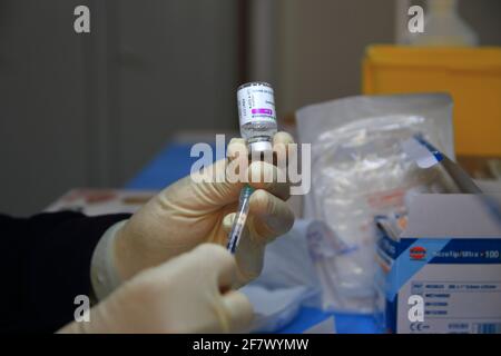Krankenschwestern in der Apotheke bereiten unter Anleitung eines Arztes Spritzen mit Dosen von pfizer-biontech-Impfstoff oder astrazeneca vor. Stockfoto