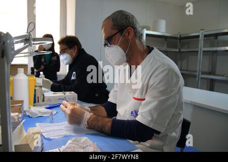 Krankenschwestern in der Apotheke bereiten unter Anleitung eines Arztes Spritzen mit Dosen von pfizer-biontech-Impfstoff oder astrazeneca vor. Stockfoto