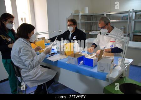 Krankenschwestern in der Apotheke bereiten unter Anleitung eines Arztes Spritzen mit Dosen von pfizer-biontech-Impfstoff oder astrazeneca vor. Stockfoto