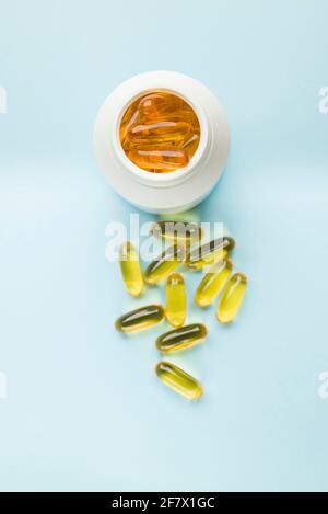 Ergänzen Gelatine Pillen auf Flasche auf blauem Hintergrund. Stockfoto