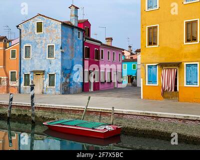 Rotes kleines Boot, das auf der berühmten Insel Burano im Dorf andockt Stockfoto