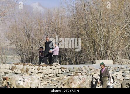 (210410) -- LHASA, 10. April 2021 (Xinhua) -- Dawa Gokye spaziert mit seinen Enkeln im Dorf Gyadu der Gemeinde Jangra im Kreis Gyangze der Stadt Xigaze, südwestlich der Autonomen Region Tibet, 22. März 2021. Dawa Gokye, 76, einst Leibeigene in einem lokalen Herrenhaus Tibets, lebte bis zur demokratischen Reform 1959 in Hoffnungslosigkeit und Verzweiflung. In den Augen der Leibeigenen sind Leibeigene nichts anderes als "sprechende Werkzeuge", die ihnen ausgeliefert sind. Dawa erinnerte sich, dass sein Kopf vom Verwalter des Herrenhauses schwer verletzt wurde, da der damals 8-Jährige das Wasser beim Brühen des Tees nicht heiß kochte. Zusammen mit Dutzenden von tho Stockfoto