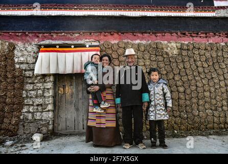 (210410) -- LHASA, 10. April 2021 (Xinhua) -- Dawa Gokye und seine Familienmitglieder posieren für ein Foto vor ihrem Wohnsitz im Dorf Gyadu der Gemeinde Jangra im Kreis Gyangze der Stadt Xigaze, südwestlich der Autonomen Region Tibet, 22. März 2021. Dawa Gokye, 76, einst Leibeigene in einem lokalen Herrenhaus Tibets, lebte bis zur demokratischen Reform 1959 in Hoffnungslosigkeit und Verzweiflung. In den Augen der Leibeigenen sind Leibeigene nichts anderes als "sprechende Werkzeuge", die ihnen ausgeliefert sind. Dawa erinnerte sich, dass sein Kopf vom Verwalter des Herrenhauses schwer verletzt wurde, da der damals 8-Jährige das Wasser während brewin nicht heiß kochte Stockfoto