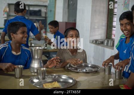 Varanasi, Indien. 10-14-2019. Gruppe von Kindern, die beim Mittagessen im Internat spielen und lächeln. Stockfoto