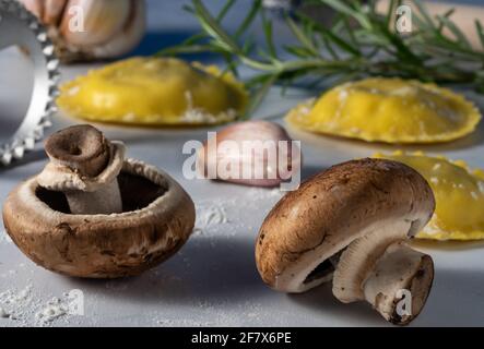 Mit Pilzen gefüllte Ravioli und rohe Zutaten. Stockfoto