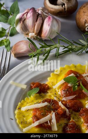 Gefüllte Ravioli mit Pilzen und Käse und Marinara-Sauce. Stockfoto