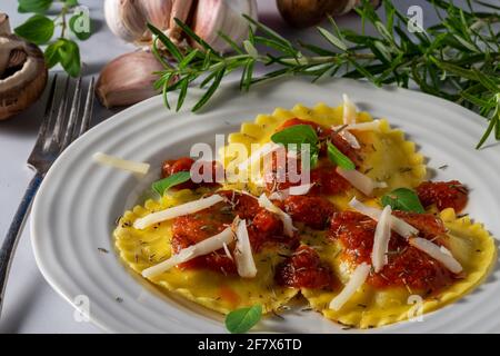 Gefüllte Ravioli mit Pilzen und Käse und Marinara-Sauce. Stockfoto