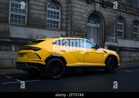 Ein 2019 gelber Giallo Auge Lamborghini Urus mit Gloss Black Leichtmetallräder und rote Bremssättel auf EINEM Manchester City Centre Street Stockfoto