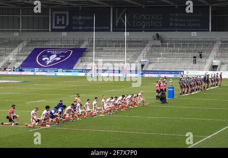 Die Spieler von St. Helens knien, während die Leeds Rhinos vor dem Start beim Spiel des Betfred Challenge Cup im total Wicked Stadium, St. Helens, stehen. Bilddatum: Samstag, 10. April 2021. Stockfoto