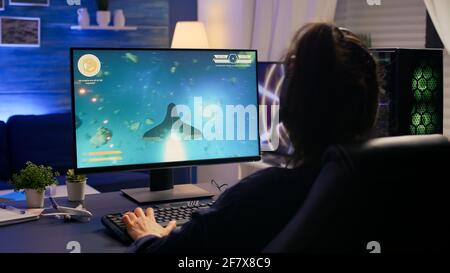 Konkurrenzfähiger Spieler, der die E-Sport-Meisterschaft verliert, indem er das drahtlose Technologie-Netzwerk verwendet. Besiegte Frau spielt online-Weltraum-Shooter-Wettbewerb mit leistungsstarken professionellen Computer Stockfoto