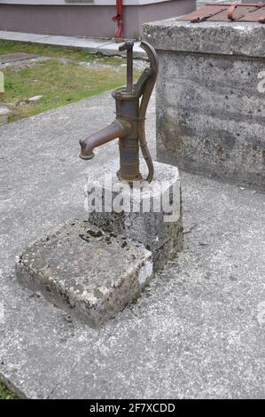 Alte rostige Wasserpumpe. Altmodische Wasserpumpe auf dem Bauernhof. Stockfoto