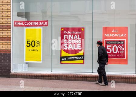 Debenhams-Laden in der High Street, Southend on Sea, Essex, Großbritannien, mit Verkaufsschildern im Schaufenster. Person, die vorbeigeht. Abschließender Abschluss, geschlossen Stockfoto