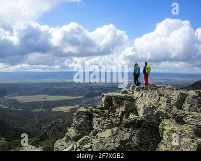 Wanderer Paar auf einem felsigen Berg mit ihren Hund genießt die malerische Aussicht Stockfoto
