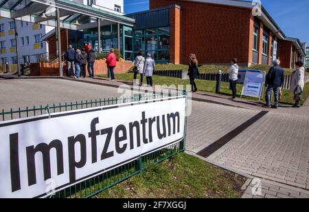 10. April 2021, Mecklenburg-Vorpommern, Wismar: Menschen stehen in einer Schlange vor dem Impfzentrum in Wismar und warten auf ihren Impftermin. Die Landesregierung Mecklenburg-Vorpommern erhöht den Druck auf Landkreise und unabhängige Städte, den Impfstoff von AstraZeneca unverzüglich einzusetzen. Foto: Jens Büttner/dpa-Zentralbild/dpa Stockfoto