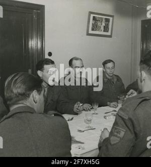 Schocktruppen von Kommando Limburg / Regiment Limburg während des Zweiten Weltkriegs. Gruppe von Soldaten am Tisch, während eines Besuchs von Z.K.H. Prinz Bernhard und seine Mitarbeiter Stockfoto