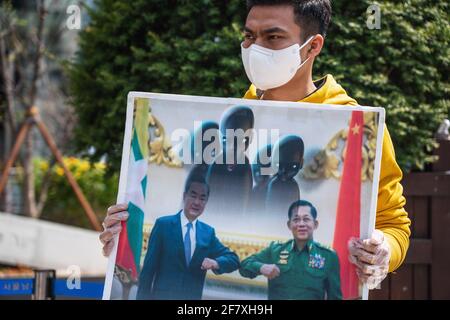 Ein Protestler hält ein Plakat mit Bildern von Min Aung Hlaing und Xi Jinping in der Nähe der chinesischen Botschaft während der Demonstration.Demokratieaktivisten aus Myanmar versammelten sich vor der chinesischen Botschaft, um die chinesische Regierung für ihre Unterstützung des Militärputsches in Myanmar zu verurteilen. Das Militär von Myanmar nahm am 01. Februar 2021 die staatliche Counselor von Myanmar, Aung San Suu Kyi, fest und verhängte den Ausnahmezustand, während es ein Jahr lang die Macht im Land ergattete, nachdem es die Wahlen gegen die National League for Democracy (NLD) verloren hatte. Stockfoto