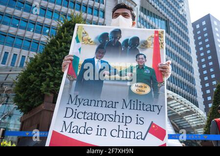 Ein Protestler hält ein Plakat mit Bildern von Min Aung Hlaing und Xi Jinping in der Nähe der chinesischen Botschaft während der Demonstration.Demokratieaktivisten aus Myanmar versammelten sich vor der chinesischen Botschaft, um die chinesische Regierung für ihre Unterstützung des Militärputsches in Myanmar zu verurteilen. Das Militär von Myanmar nahm am 01. Februar 2021 die staatliche Counselor von Myanmar, Aung San Suu Kyi, fest und verhängte den Ausnahmezustand, während es ein Jahr lang die Macht im Land ergattete, nachdem es die Wahlen gegen die National League for Democracy (NLD) verloren hatte. Stockfoto