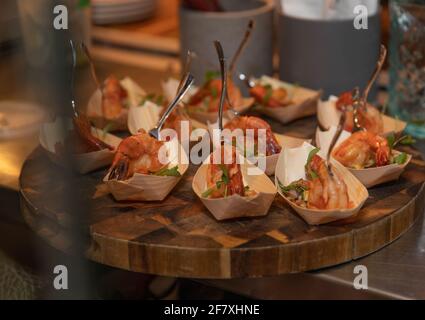 Kleine Tassen gefüllt mit Fingerfood auf einem Teller an Eine Party Stockfoto